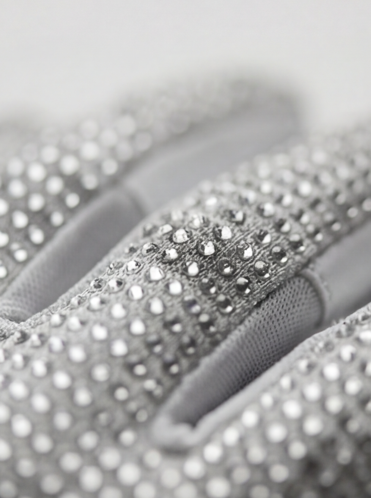 Close-up of a hand wearing a silver glove with rhinestone embellishments.